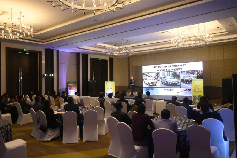A corporate seminar event organized by PixxelMonk, featuring a speaker giving a presentation to a seated audience at round tables inside a hotel ballroom