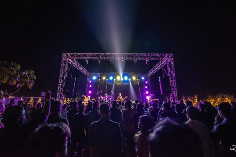 Outdoor festival crowd and dynamic stage truss lighting managed by PixxelMonk