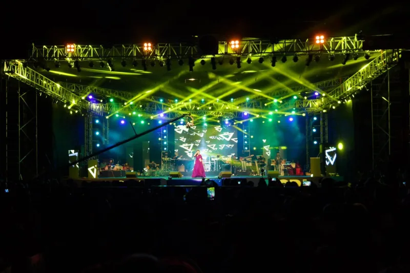 Large-scale concert stage production with green laser light show and live singer
