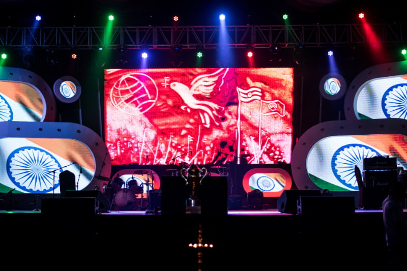 Large event stage setup featuring Indian national flag colors and graphics on LED screens for a patriotic celebration.