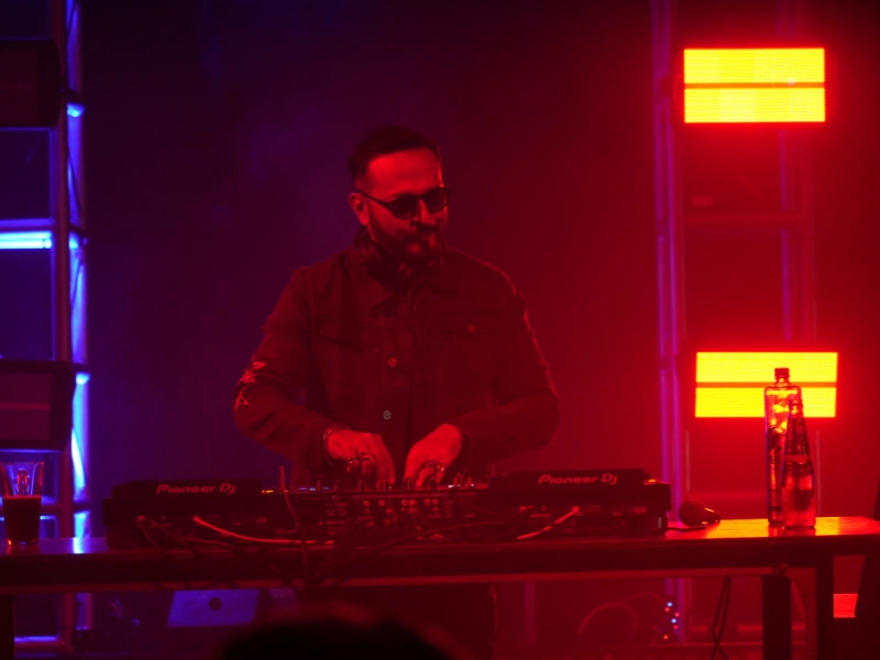 DJ nihkil chinapa performing with red lighting hues by pixxelmonk